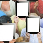 holding tablets in front the faces banner