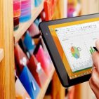 Shop keeper checking candle inventory on a tablet