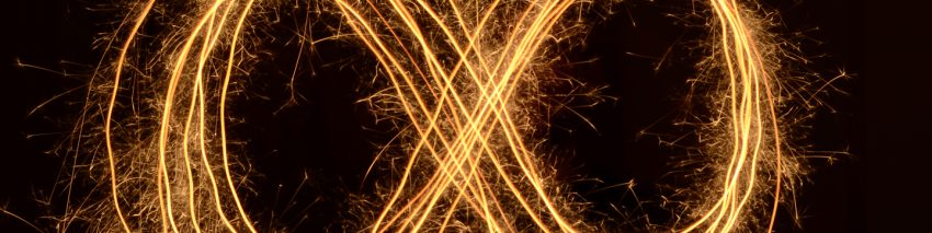 Over a black background, golden light streaks in the pattern of an "X" inscribed in a circle